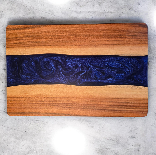 Top view of handmade tigerwood serving tray with swirling deep blue epoxy center and routed handles 