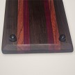 Close-up of the rubber feet and striped purpleheart and red zebrawood end of the whiskey tray 